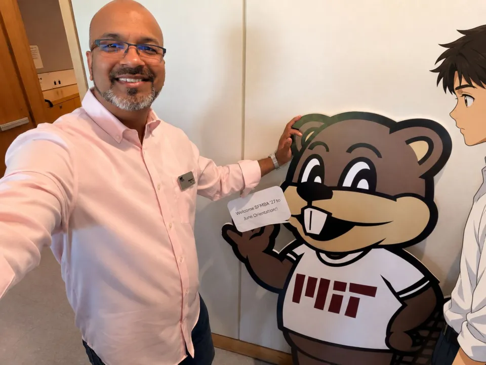 Prashant at MIT Sloan orientation, next to a sign welcoming the Sloan Fellows MBA class of 2027